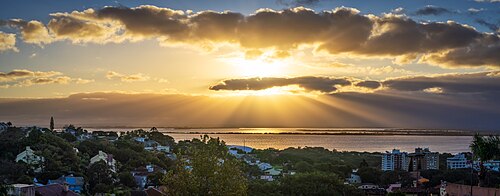 Sun striking through the clouds over Guaiba river