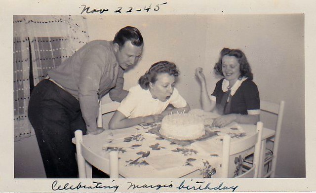 A woman blowing out the candles on her birthday cake